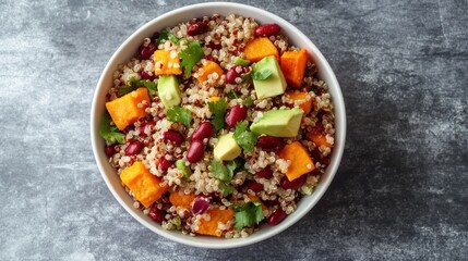 On a gray background, quinoa salad with avocado, sweet potato, and beans. superfood idea. Clean, healthful eating philosophy. A gluten-free or vegan diet. upper view.