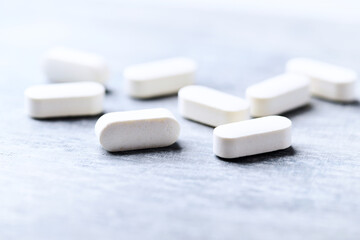 Amino acids tablets. Nutrition for bodybuilding. Fitness supplements on bright wooden background. Soft focus. Copy space.	