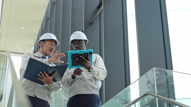 建物の中で会話する多国籍エンジニアのグループ