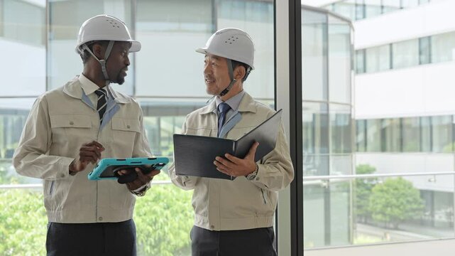 建物の中で会話する多国籍エンジニアのグループ