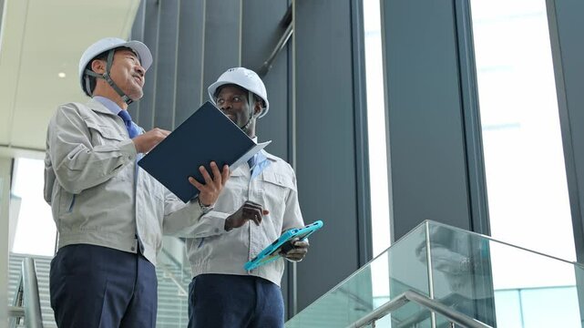 建物の中で会話する多国籍エンジニアのグループ