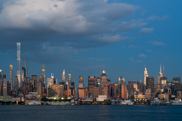 Naklejka premium New York City Skyline at Dusk with Illuminated Skyscrapers and Waterfront.
