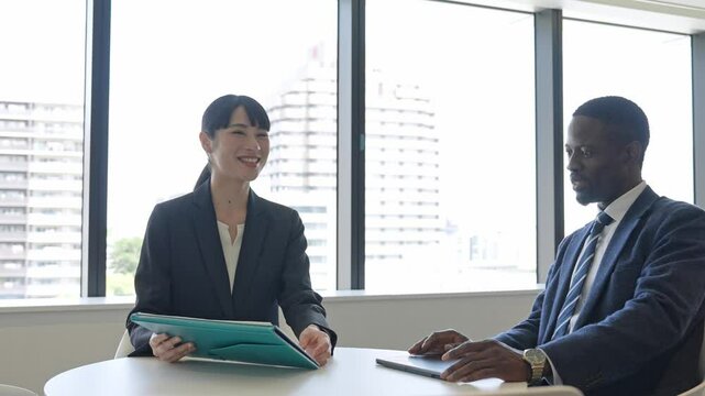 ロビーで会話する多国籍ビジネスパーソンのグループ