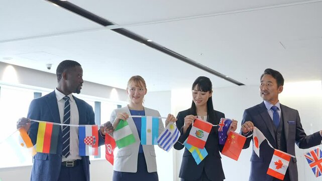 万国旗を持って並ぶ多国籍ビジネスパーソンのグループ