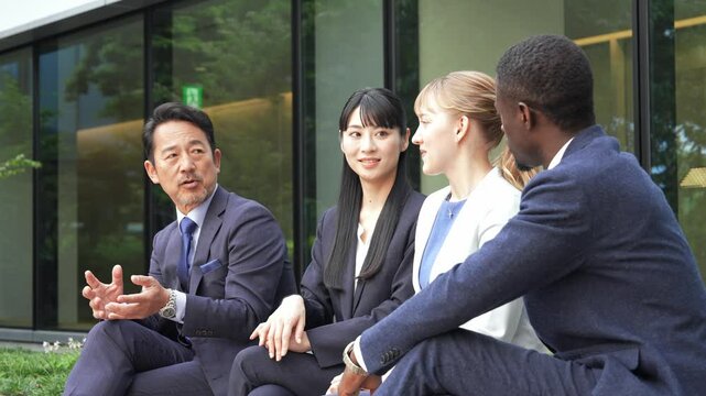 リラックスして話をする多国籍ビジネスパーソンのグループ