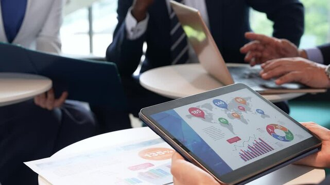 タブレットを見ながら会議するビジネスパーソンのグループ