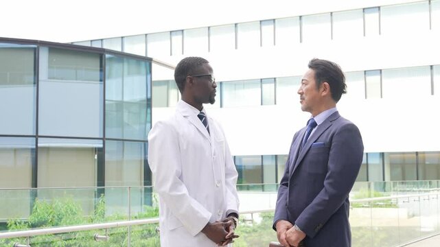 会話する白衣の外国人男性とビジネスマン