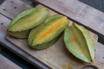 Three Whole fruit of Averrhoa Carambola also known as starfruit, carambola and five-corner, on a wooden cutting board, tropical  fruits.