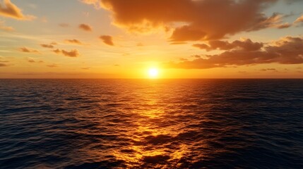 Fototapeta premium A serene sunset over the ocean, casting warm hues across the water, with fluffy clouds and a tranquil atmosphere.