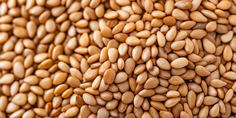 Fototapeta premium A high-quality close-up image of sesame seeds with a detailed texture, showcasing their golden brown tones, ideal for culinary, nutrition, and healthy eating themes