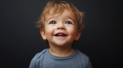 Naklejka premium A baby with blonde hair laughs with missing teeth.