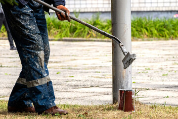 The painter paints the pole to protect it from corrosion.