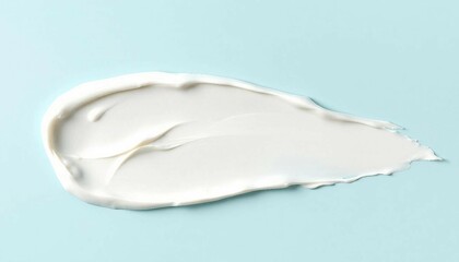 A smudge swatch smear of white cream on a blue background. Pureness concept