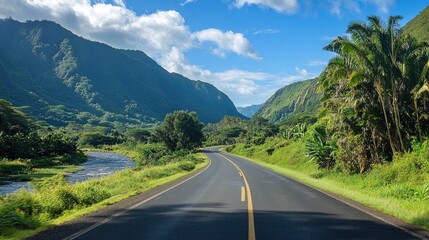Naklejka premium A scenic asphalt highway through a lush valley, with mountains rising on both sides and a river running alongside the road.