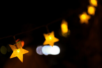 Star-shaped string lights in the dark night, close-up shot