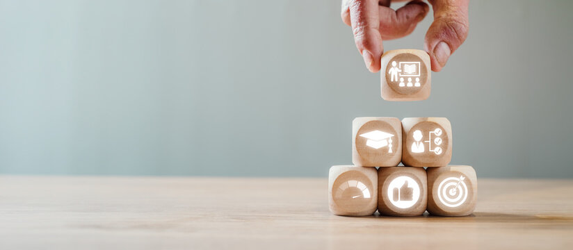 Wooden blocks with icons symbolizing apprenticeship, education, and career growth, illustrating the concept of skill development and learning.