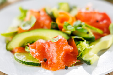 Plate of smoked salmon with avocado and lettuce. Perfect for healthy meals and light gourmet dishes