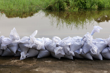 Sandbag for flood protection. A pile or wall of sandbags at the front gate or entrance of a house to keep flood water out of the residence