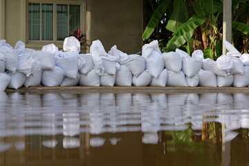 Sandbag for flood protection. A pile or wall of sandbags at the front entrance of a house, next to...