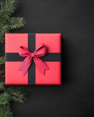 A beautifully wrapped red gift box with a black ribbon and a pine branch, perfect for holiday celebrations and surprises.