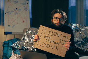 A paranoid man with a sign in his hands.