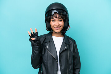 Young Argentinian woman with a motorcycle helmet isolated on blue background happy and counting three with fingers