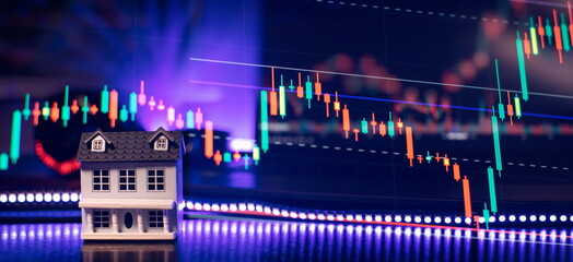 House model on the background of the stock market. The concept of buying a house.Real estate concept