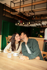 Joyful coffee conversation between friends in a cozy cafe surrounded by vibrant art on a sunny afternoon