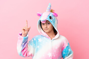 Little caucasian woman wearing a unicorn pajama isolated on pink background showing and lifting a finger in sign of the best