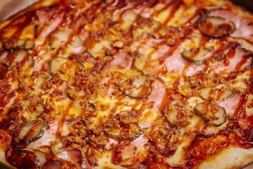 A delicious pizza topped with thin slices of prosciutto, melted cheese, and caramelized onions on a crispy golden crust. The rich colors and textures highlight the mouth-watering ingredients.
