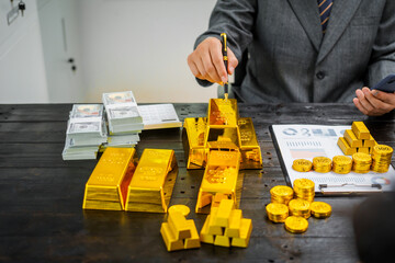 Businessman in suit sits at his desk, holding a shining gold bar. financial charts, the scene symbolizes wealth, investment success, growing influence of cryptocurrency and blockchain.