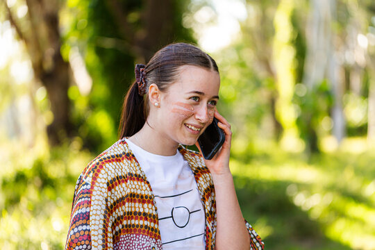 Happy young Aussie person making phone call on mobile device