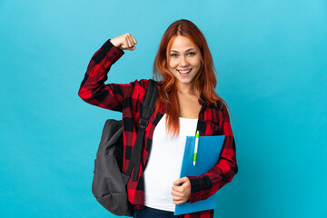Teenager student Russian girl isolated on blue background doing strong gesture