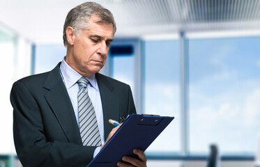 Fototapeta premium Senior executive reviewing documents outdoors