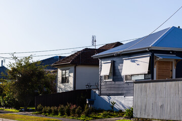 weatherboard houses with awnings over windows and electricity wires connecting to roof