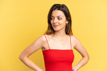 Young caucasian woman isolated on yellow background having doubts while looking side