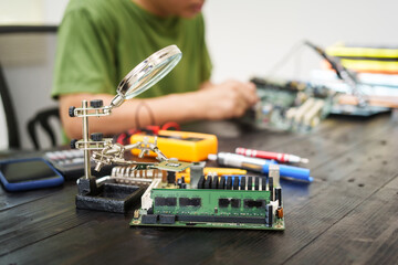 Technician carefully repairs a computer circuit board, using precision tools to address hardware...