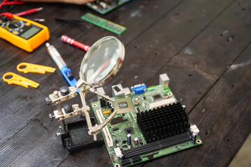 Technician carefully repairs a computer circuit board, using precision tools to address hardware...
