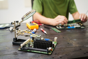 Technician carefully repairs a computer circuit board, using precision tools to address hardware...