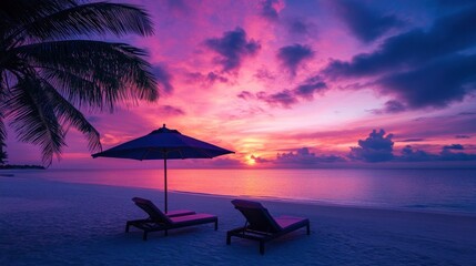 Naklejka premium Lovely tropical sunset view with two sun loungers, an umbrella, and palm trees. White sand, a vivid twilight sky, a view of the sea and the horizon, serenity and relaxation. Awe-inspiring beach resort