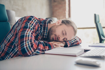 Photo of nice young man company worker sleep desk wear checkered shirt modern loft office indoors