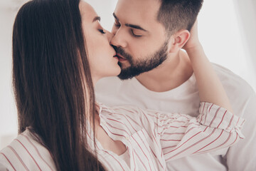 Photo of cheerful cute young couple enjoy weekend couple wife husband kissing buy new apartment indoors inside house home