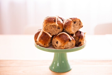 easter hot cross buns piled onto a cake stand