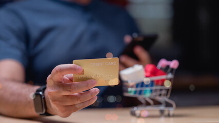 People shopping online using phones concept. Person holds credit card while shopping online, emphasizing convenience and accessibility of digital transactions and modern shopping experiences in world