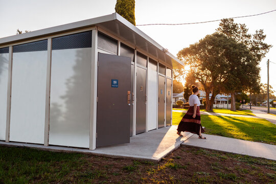 Woman leaving public toilet facilities in park