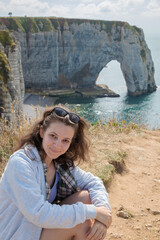 Tourist girl next to chalk cliffs in Etretat, Normandy, France