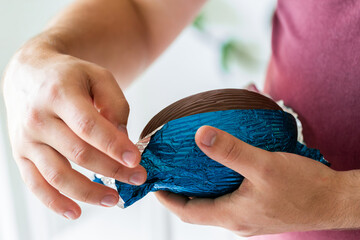 Adult holding foil-wrapped easter egg in hand