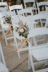 Stuhldekoration bei einem Event oder einer Hochzeit draussen mit Blumenarrangement