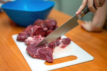 sharp knife glides effortlessly through tender beef fillet on a rustic home table, evoking the...