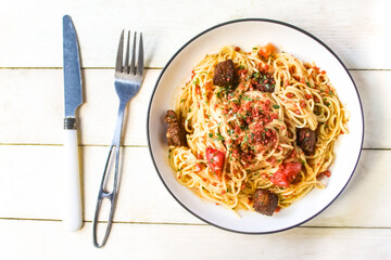 spaghetti dish with toppings and meat on the table